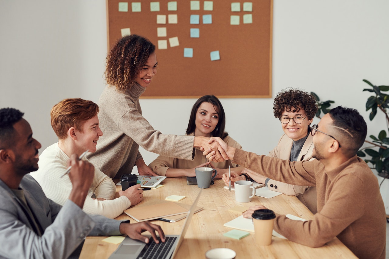 Co-Workers shaking hands across a table
